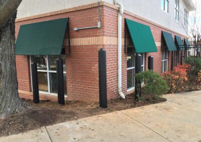 Black bollards near brick building
