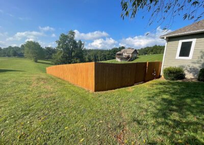 Wooden fence in grassy landscape.