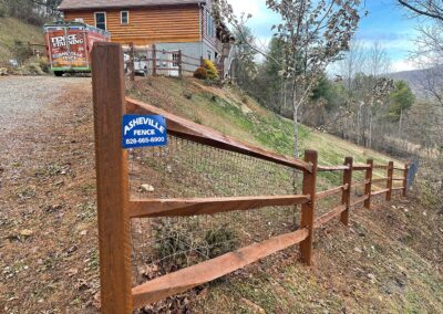 Wooden fence along a hillside property.