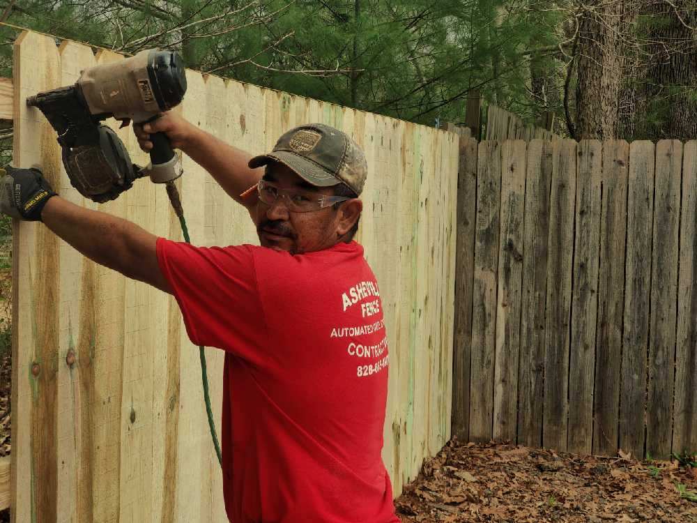 Worker building a wood privacy fence