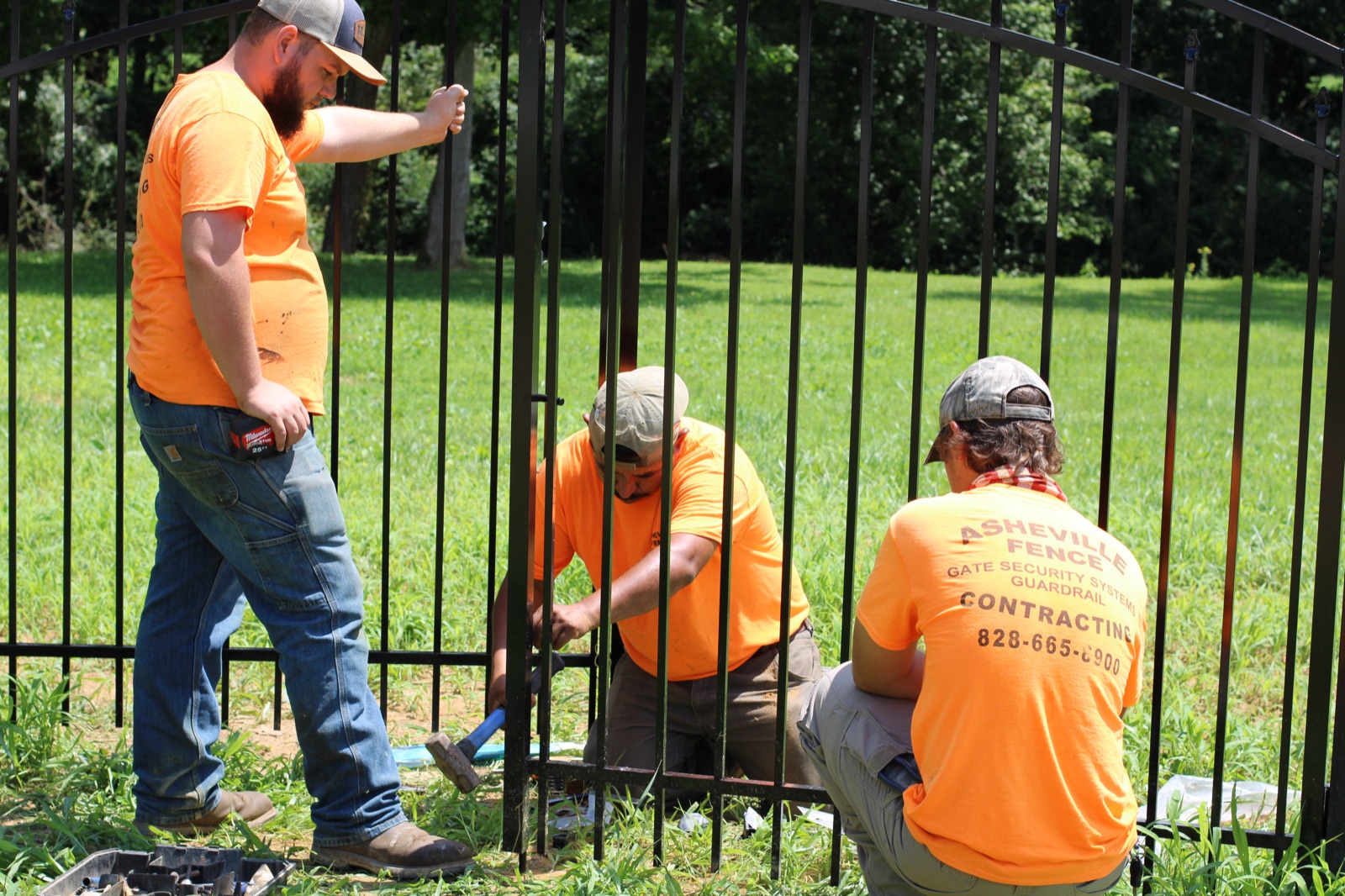 Asheville Fence crew installing a custom aluminum gate