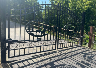 Black ornamental double swing driveway gate with deer medallions and two LiftMaster gate operators