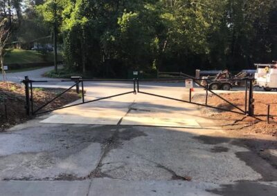 Double swing pipe barrier gate across a paved business entrance