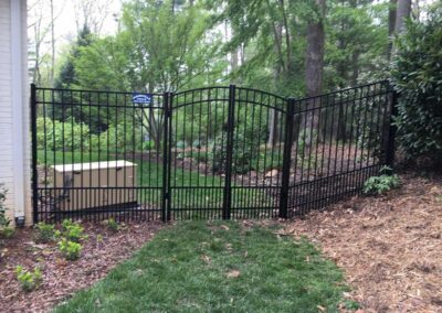Black gate opening to green garden